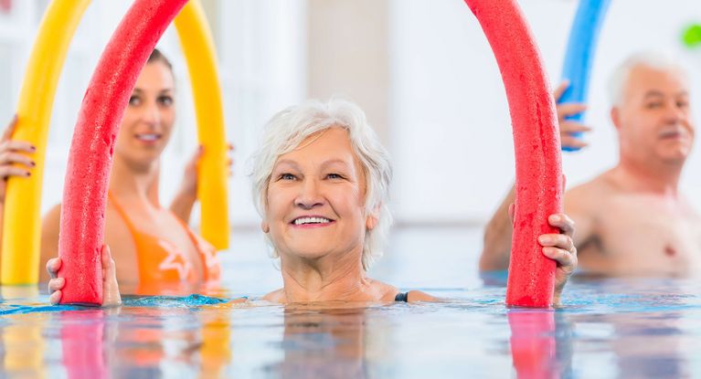 Patientinnen üben mit Poolnudeln im Wasser