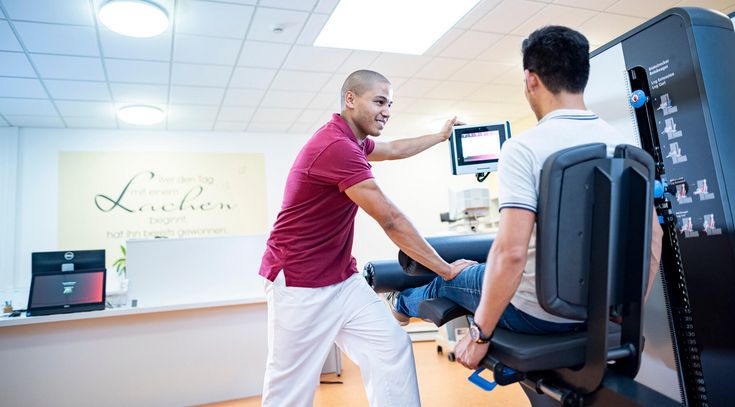 Therapeut unterstützt Patient in der Medizinische Trainingtherapie