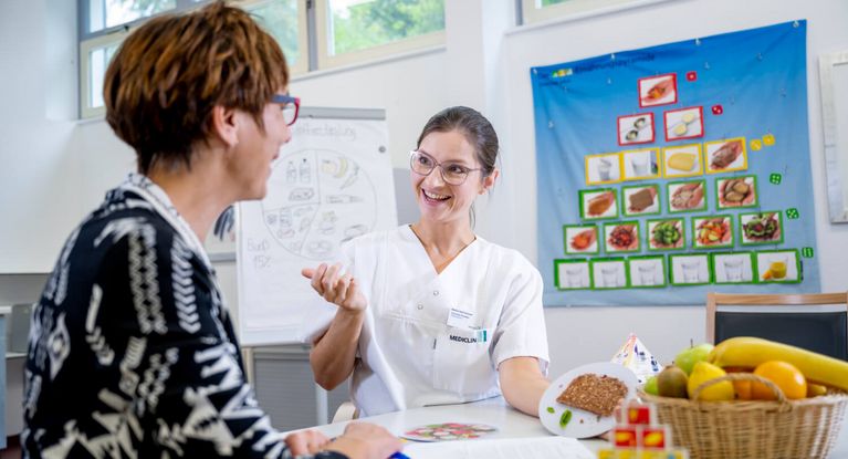 Ernäherungsberaterin erklärt Patientin die Ernährungspyramide