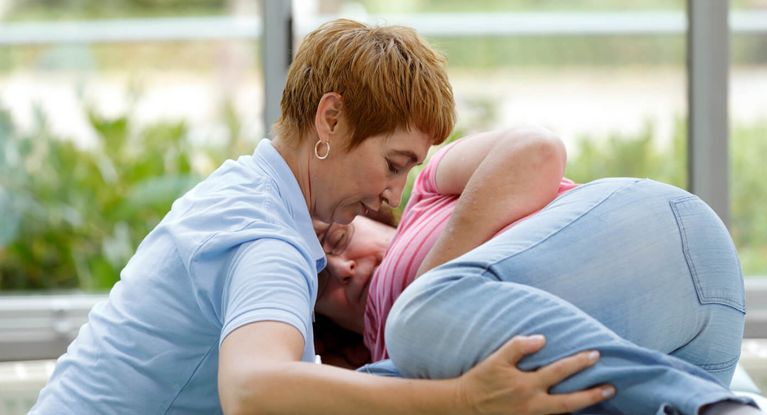 Physiotherapie Therapeutin massiert älteren Patienten