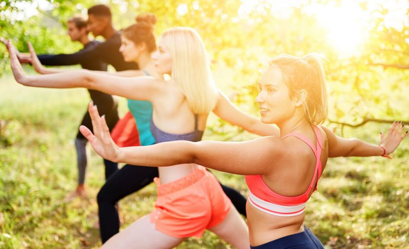 eine Gruppe junger Menschen macht Thai Chi draußen im Park