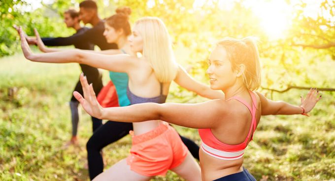eine Gruppe junger Menschen macht Thai Chi draußen im Park