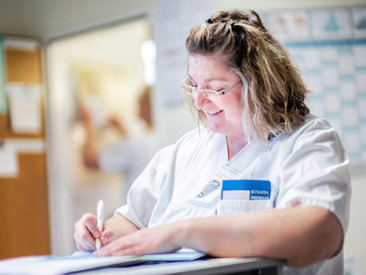 Pflegekraft schreibt in Patientenakte