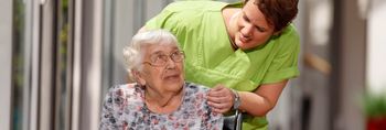 Pflegekraft spricht mit älterer Patientin
