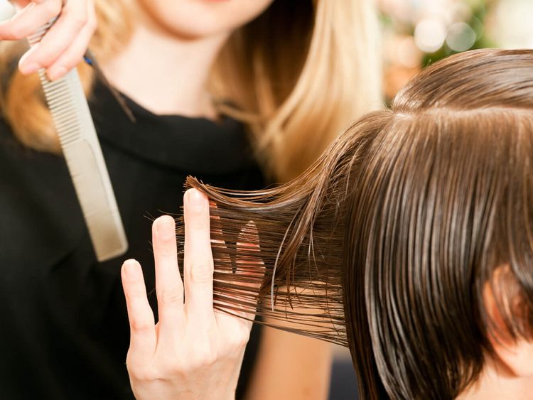 Friseuse ordnet Frisur einer Kundin