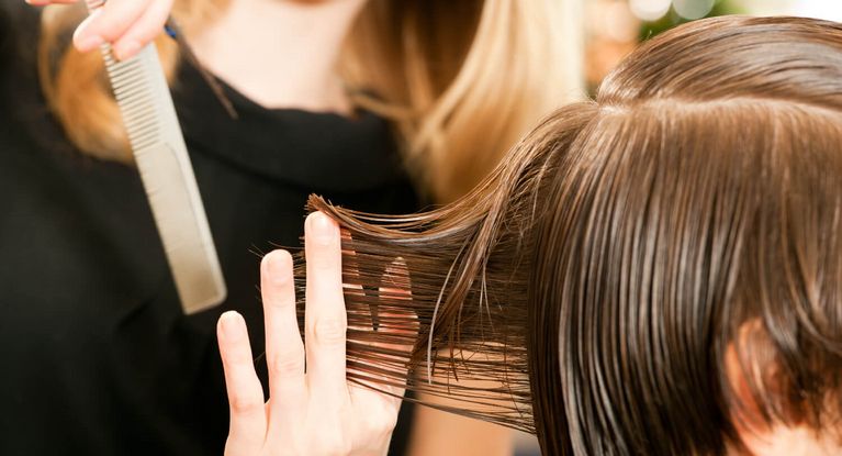 Friseuse ordnet Frisur einer Kundin