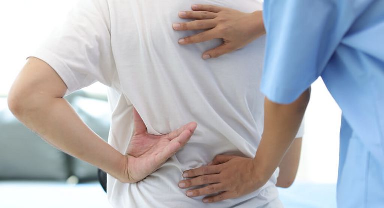 Arzt prüft den Rücken eines Patienten
