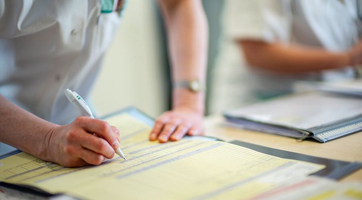 Pflegekräfte füllen Patientenakten aus