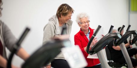 Therapeutin unterstützt älteren Patienten bei der medizinische Trainingstherapie 