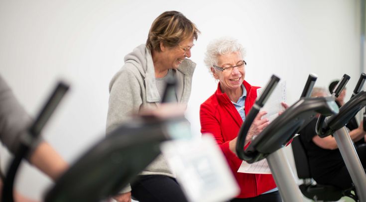 Therapeutin unterstützt älteren Patienten bei der medizinische Trainingstherapie 