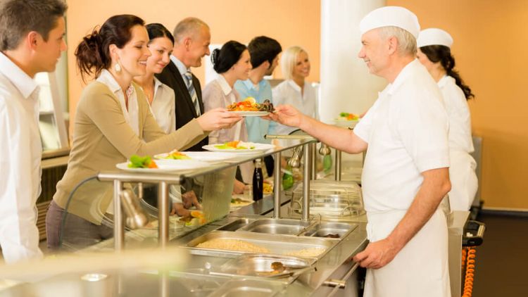 Köche servieren Essen in einer Kantine