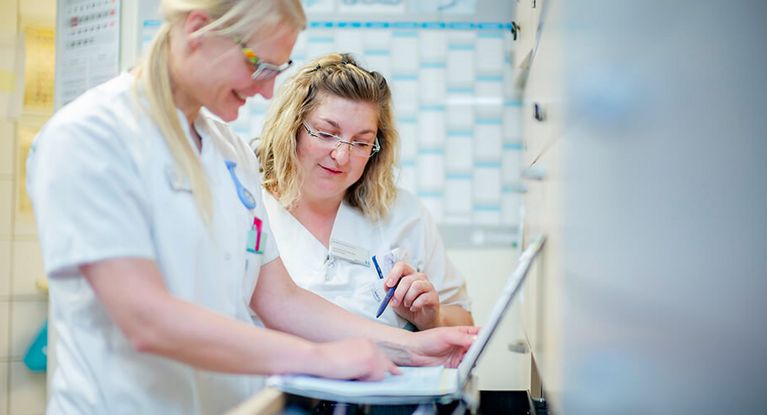 Pflegekräfte besprechen Patientenakte