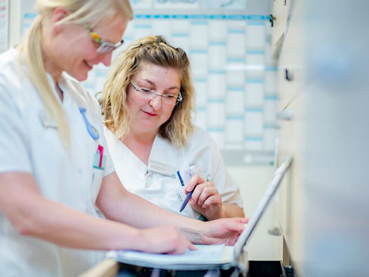Pflegekräfte besprechen Patientenakte